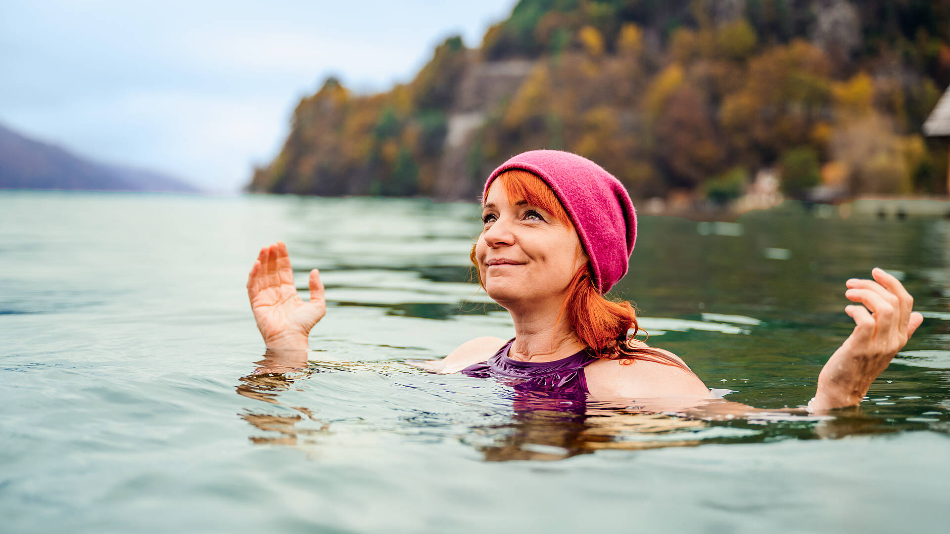 Frau ist mit Mütze im Herbst im Millstätter See Kaltbaden