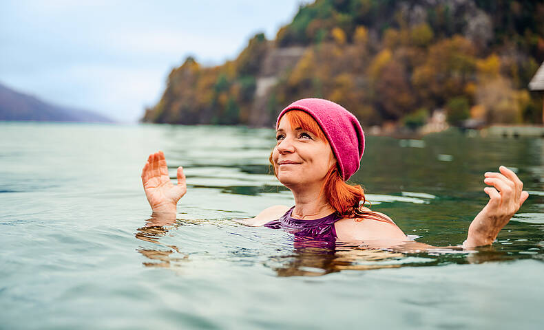 Frau ist mit Mütze im Herbst im Millstätter See Kaltbaden