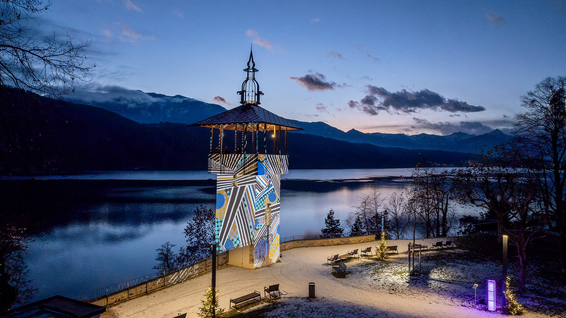 Stimmungsvoller Ausblick auf den beleuchteten Turm mit dem Millstätter See im Hintergrund