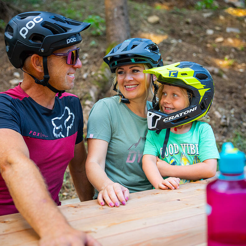 Familie mit Kind und Mountainbikes macht eine Pause im Skillscenter der Bike Area Obermillstatt.